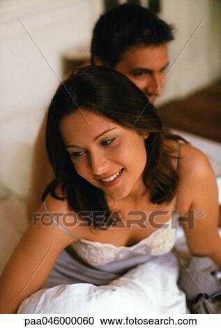Couple on bed, focus on woman in foreground View Large Photo Image Stock Image - Couple on bed, focus on woman in foreground. Fotosearch