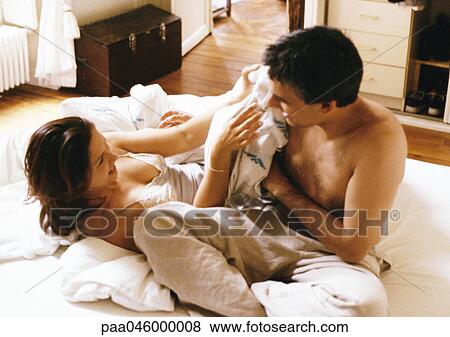 Man and woman playfighting on bed View Large Photo Image Stock Photo - Man and woman playfighting on bed. Fotosearch