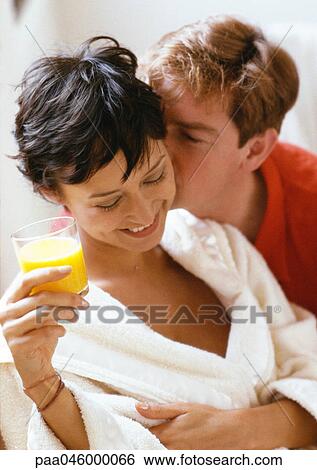 Man kissing woman from behind, woman holding glass of juice, head and shoulders, close-up View Large Photo Image Stock Photograph - Man kissing woman from behind, woman holding glass of juice, head and shoulders, close-up. Fotosearch
