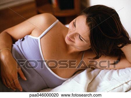 Woman laying in bed, smiling View Large Photo Image Stock Image - Woman laying in bed, smiling. Fotosearch