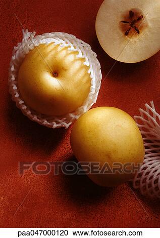 Stock Image - Asian pears, one in cross section, high angle view, close-up. Fotosearch