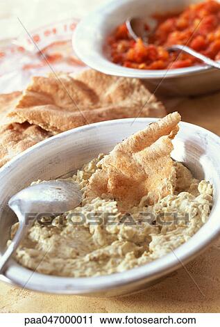 Stock Image - Bowl of baba ghannouj with pita bread, close-up. Fotosearch