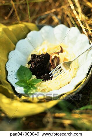 Stock Photo - Butter with olives in bowl, close-up. Fotosearch