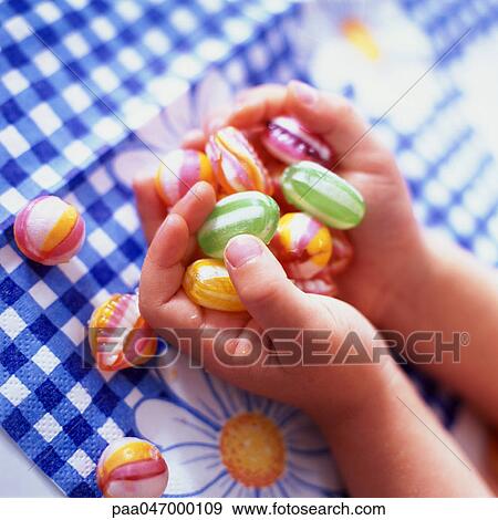 Child's hands holding candy, close-up View Large Photo Image Stock Photo - Child's hands holding candy, close-up. Fotosearch