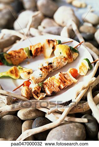 Fish kebabs on plate among stones and branches View Large Photo Image Stock Image - Fish kebabs on plate among stones and branches. Fotosearch