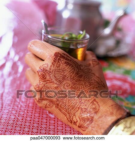 Hand with henna motif holding glass of mint tea, close-up View Large Photo Image Stock Image - Hand with henna motif holding glass of mint tea, close-up. Fotosearch