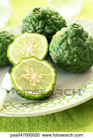 Kaffir limes, one cut in half, on plate, close-up View Large Photo Image Stock Image - Kaffir limes, one cut in half, on plate, close-up. Fotosearch