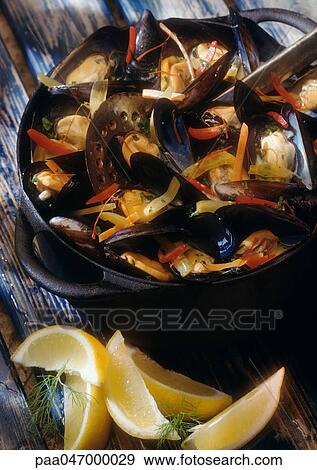 Mussels in white wine in pot with lemon wedges on the side, close-up View Large Photo Image Stock Photo - Mussels in white wine in pot with lemon wedges on the side, close-up. Fotosearch