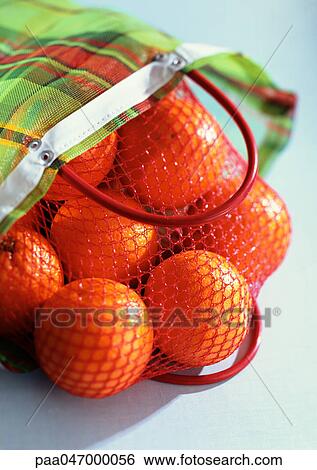 Stock Photograph - Oranges in mesh bag, close-up. Fotosearch