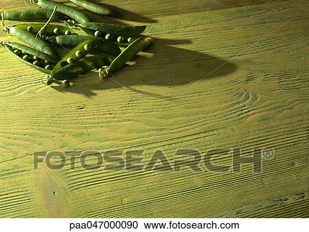 Peas in open pods on wood table, off centered View Large Photo Image Stock Image - Peas in open pods on wood table, off centered. Fotosearch