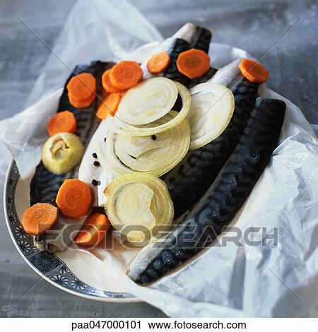 Stock Image - Raw mackerel with onions and carrots, close-up. Fotosearch