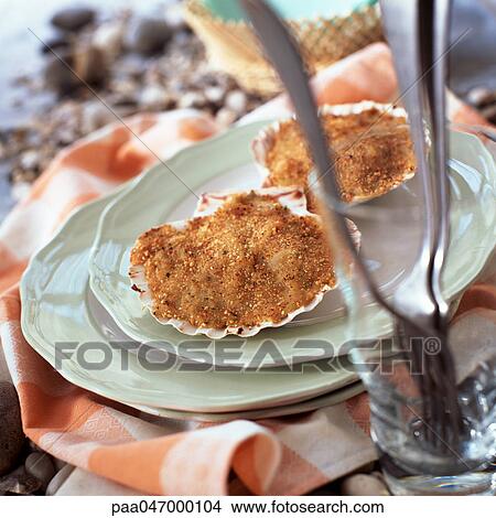 Picture - Stuffed scallops on plate, forks blurred in foreground, close-up. Fotosearch