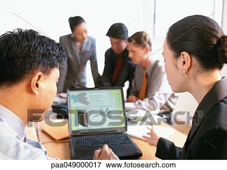 Stock Photo - Businesspeople working in office. Fotosearch