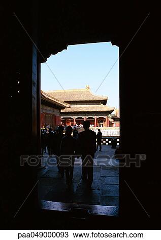 Stock Image - China, Beijing, doorway and silhouette of people in Forbidden City. Fotosearch