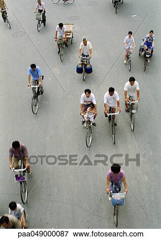 Stock Photo - China, Beijing, people riding bicycles in street, elevated view. Fotosearch