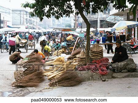 Stock Image - China, Guangxi Autonomous Region, Laibin, broom seller at open-air market. Fotosearch