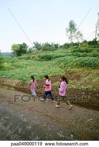 China, Guangxi Autonomous Region, children walking along dirt road in rural area View Large Photo Image Stock Photo - China, Guangxi Autonomous Region, children walking along dirt road in rural area. Fotosearch