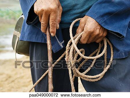 China, peasant holding rope and wood stick, mid-section, close-up View Large Photo Image Stock Image - China, peasant holding rope and wood stick, mid-section, close-up. Fotosearch