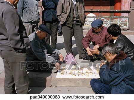 China, Xinjiang Province, Urumqi, group of people playing mah-jong on ground View Large Photo Image Stock Photo - China, Xinjiang Province, Urumqi, group of people playing mah-jong on ground. Fotosearch