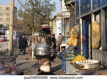 Stock Photograph - China, Xinjiang, Urumqi, food being sold on sidewalk. Fotosearch