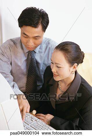 Man and woman looking at computer screen View Large Photo Image Picture - Man and woman looking at computer screen. Fotosearch