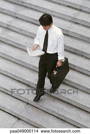 Picture - Man reading on stairs, high angle view. Fotosearch