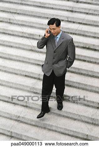 Man using cell phone on stairs, high angle view View Large Photo Image Stock Image - Man using cell phone on stairs, high angle view. Fotosearch