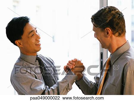 Two men shaking hands, side view View Large Photo Image Stock Image - Two men shaking hands, side view. Fotosearch