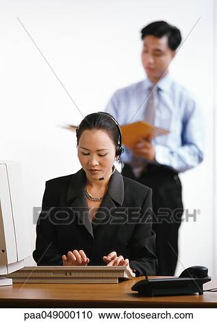 Woman typing on keyboard, man in background View Large Photo Image Stock Image - Woman typing on keyboard, man in background. Fotosearch