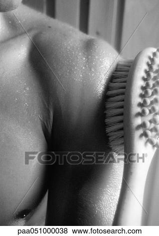 Stock Photo - Brush on bare shoulder in sauna, close-up, b&w. Fotosearch