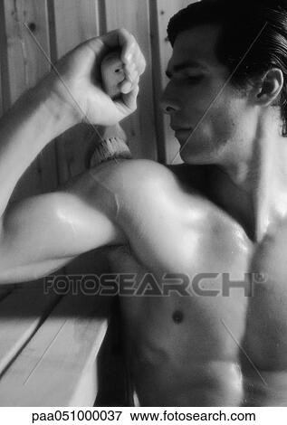 Stock Photo - Man brushing back in sauna, close-up, b&w. Fotosearch