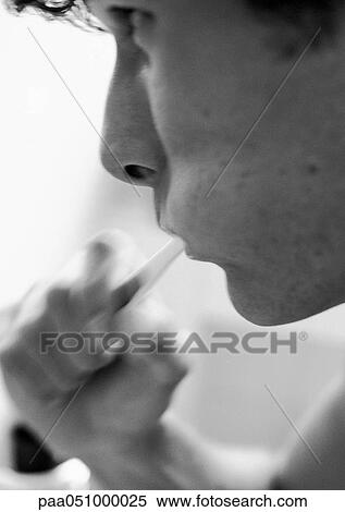 Stock Photography - Man brushing teeth, close-up, b&w. Fotosearch
