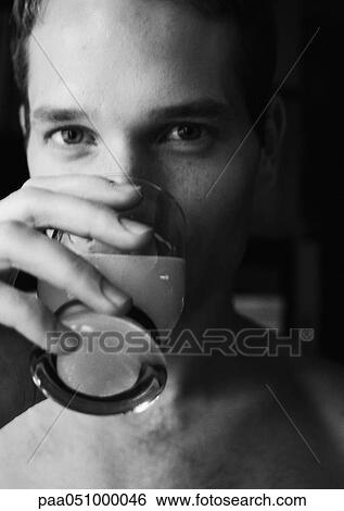 Man drinking and looking at camera, close-up, b&w View Large Photo Image Stock Photograph - Man drinking and looking at camera, close-up, b&w. Fotosearch