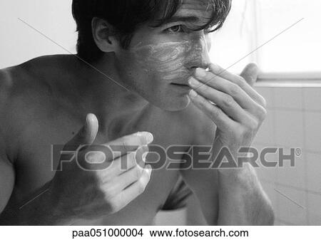 Picture - Man putting cream on face, b&w. Fotosearch