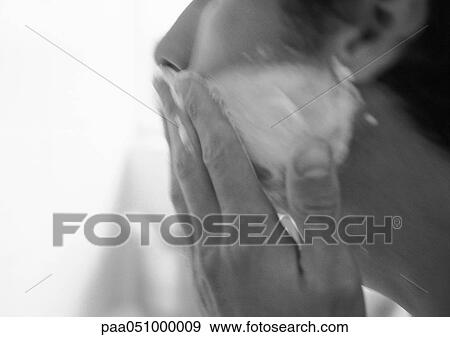 Stock Photo - Man putting cream on face, side view, close-up, blurred, b&w. Fotosearch