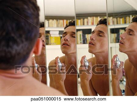 Stock Photography - Man putting on cologne, reflecting in mirrors. Fotosearch