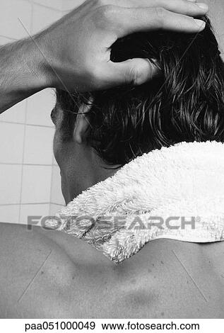 Stock Photo - Man with towel around neck and hand on hair, rear view, close-up, b&w. Fotosearch