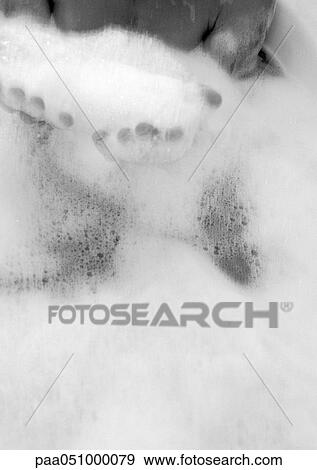 Stock Photo - Person taking bath, foam in hands, b&w. Fotosearch