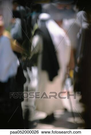 Stock Photograph - Israel, Jerusalem, man wearing djellaba, rear view, blurred. Fotosearch