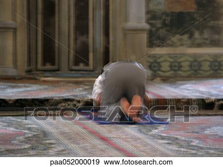Stock Photo - Israel, Jerusalem, Muslim man praying in mosque, rear view, blurred. Fotosearch