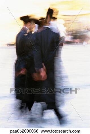 Stock Photograph - Israel, Jerusalem, Orthodox Jews walking in street, blurred. Fotosearch