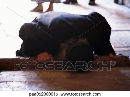 Stock Photography - Israel, Jerusalem, person touching head to ground, blurred. Fotosearch