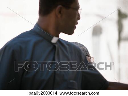 Priest looking back over shoulder, blurred View Large Photo Image Picture - Priest looking back over shoulder, blurred. Fotosearch