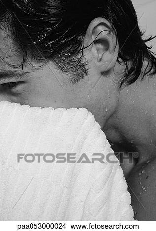 Picture - Man towel-drying face, side view, close-up, b&w. Fotosearch