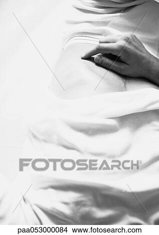 Picture - Man's hand on stomach, b&w. Fotosearch