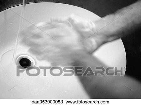 Stock Image - Man's hands above sink, blurred, b&w. Fotosearch