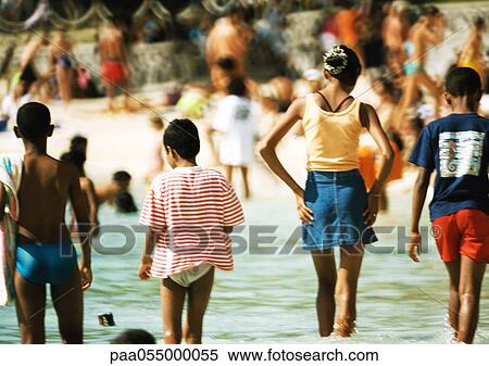 Children standing in sea, rear view, crowd in background, blurred View Large Photo Image Stock Photography - Children standing in sea, rear view, crowd in background, blurred. Fotosearch