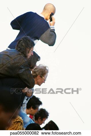 Stock Image - Group of people outside, rear view, tilt. Fotosearch