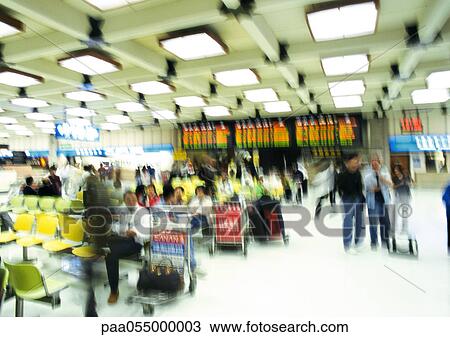 Stock Image - People in airport terminal, blurred. Fotosearch