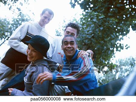 Four young people outside, smiling View Large Photo Image Stock Photo - Four young people outside, smiling. Fotosearch